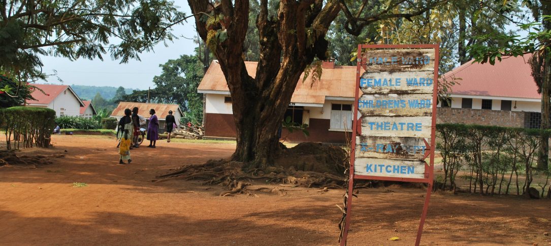 A sign outside of a modest building says, "Male ward, Female ward, children's ward, kitchen, x-rays