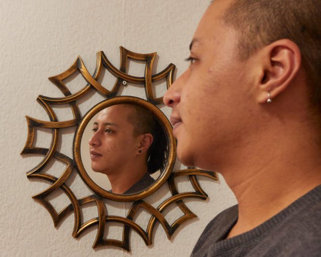 Young person reflected in a mirror on the wall